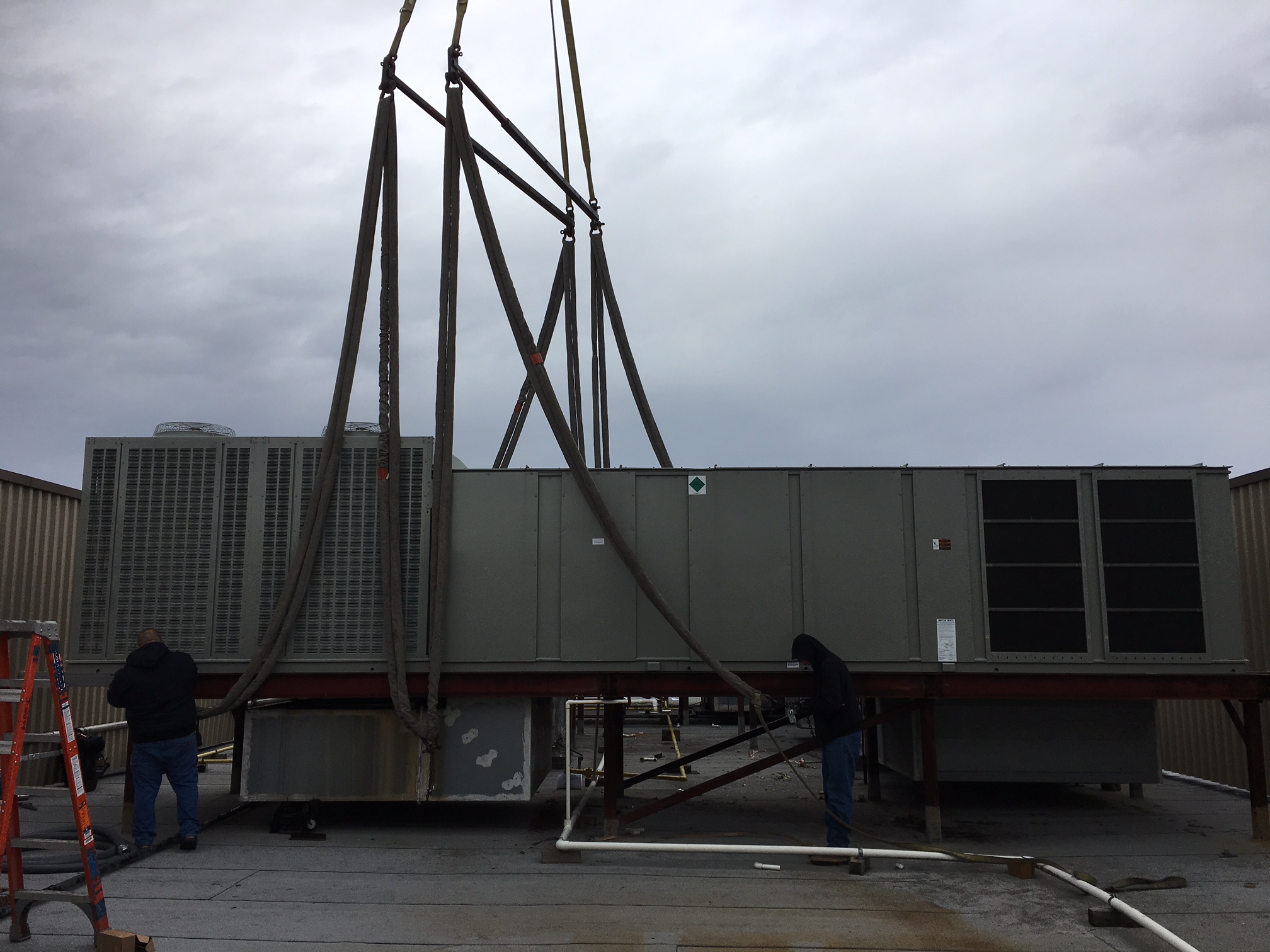 new hvac unit getting placed on roof by crane