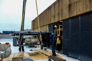 crane installing commercial hvac system on roof