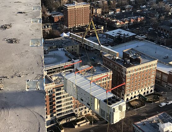 hvac unit being lifted to rooftop by crane