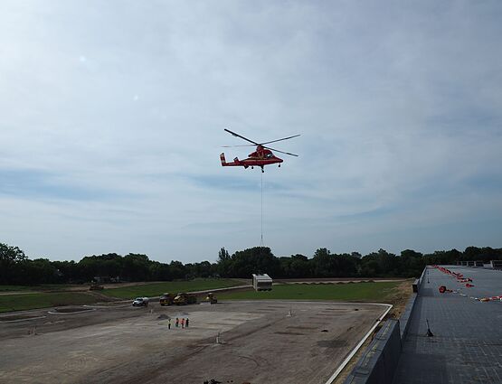 helicopter placing hvac unit on roof of building