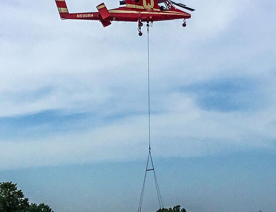 helicopter placing hvac unit on roof of building